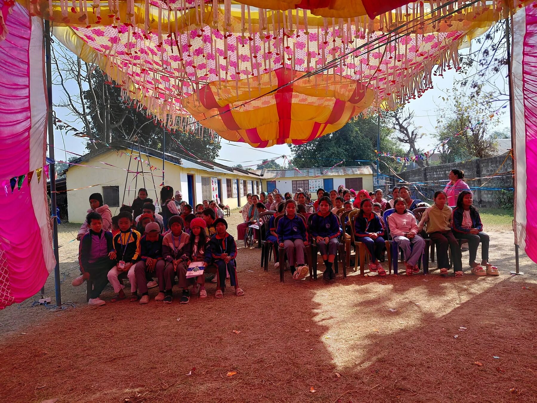 Students seated in warm red sweaters in front of the classrooms