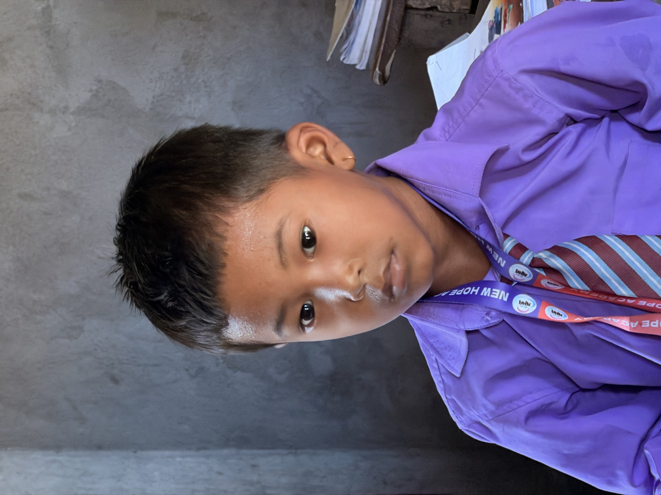 A young student in uniform and school tie, calm and thoughtful