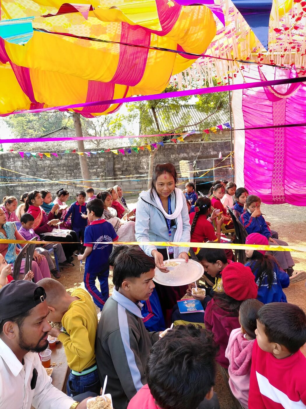 Teachers handing out gifts to a crowd of excited students