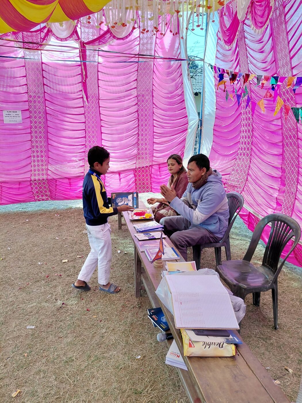 A student standing at the prize table receiving his award